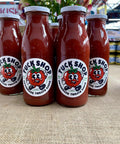 Tuck Shop Housemade Tomato Sauce bottles in a stack of four on a hessian tablecloth